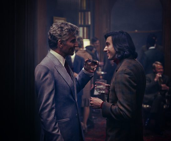 Maestro. (L to R) Bradley Cooper as Leonard Bernstein, (Director/Writer/Producer) and Gideon Glick as Tommy Cothran in Maestro. Cr. Jason McDonald/Netflix © 2023.